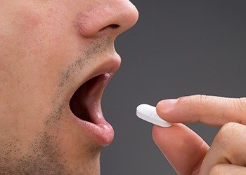 Man taking an oral sedative pill