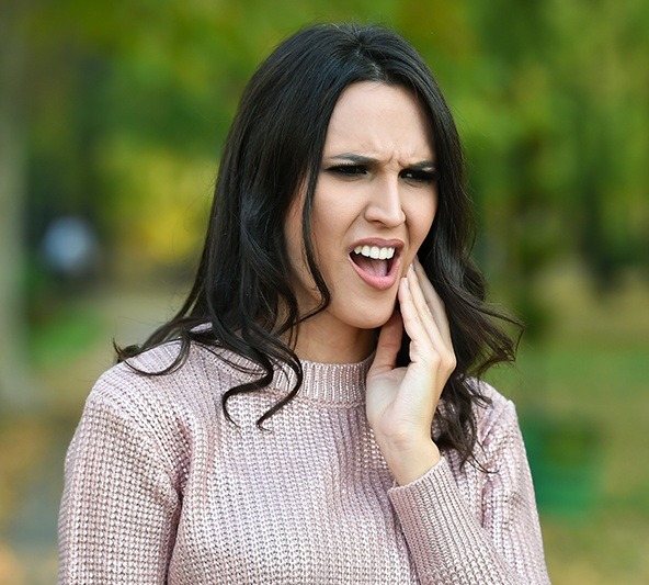 Woman in pain holding jaw