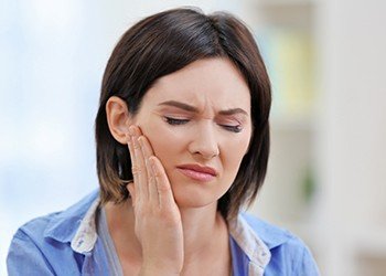 Woman holding jaw in pain