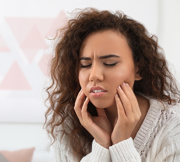 Woman holding cheeks in pain