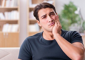 Man holding jaw in pain