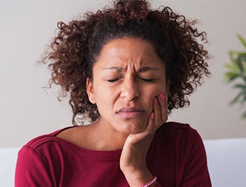 Woman holding jaw in pain