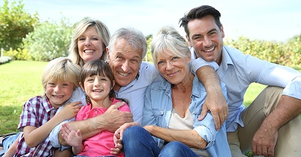 Three generations of family smiling outdoors