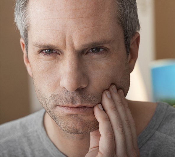 Older man holding jaw